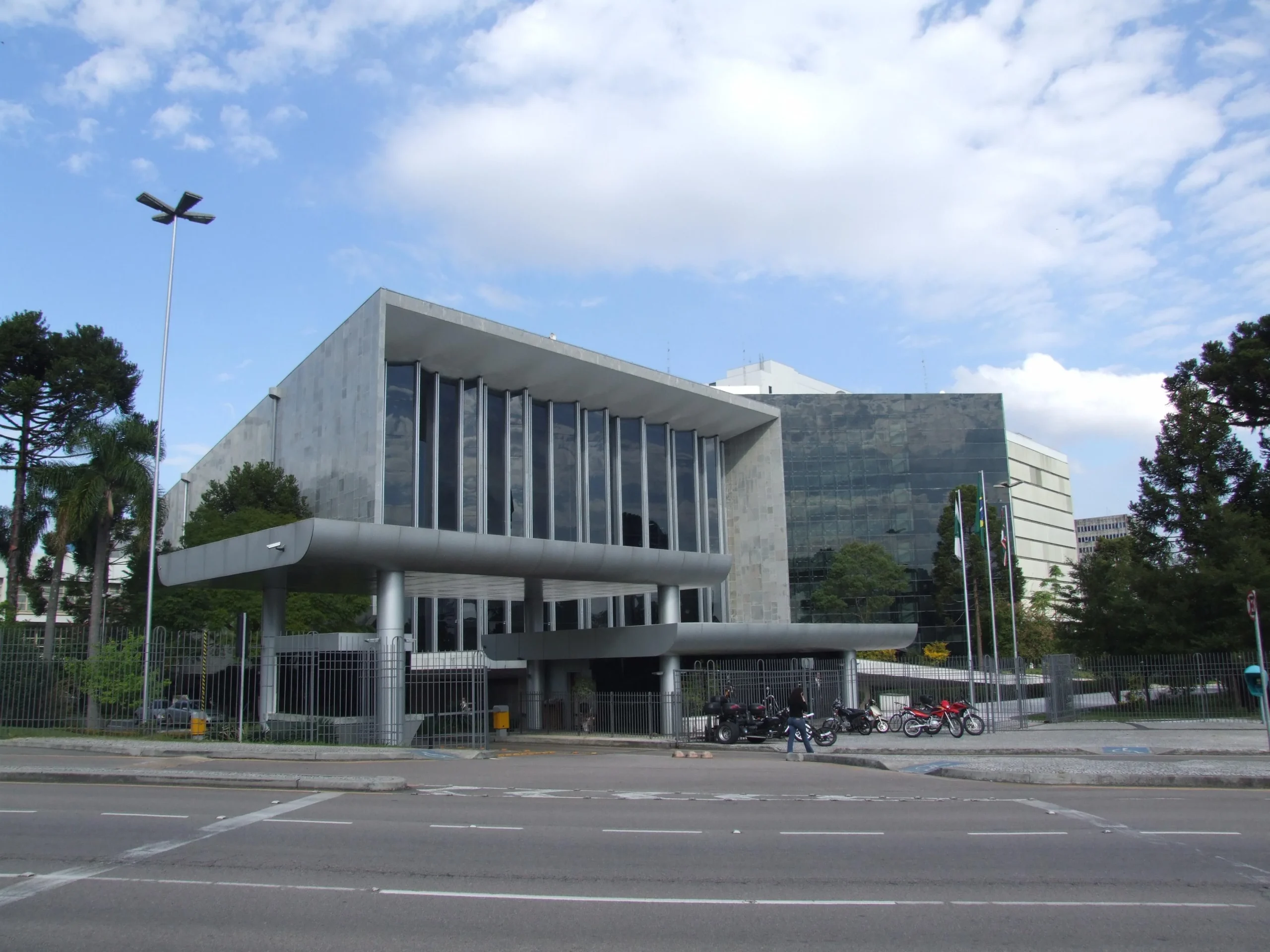 Fachada moderna da Assembleia Legislativa estadual com bandeiras e arquitetura cívica