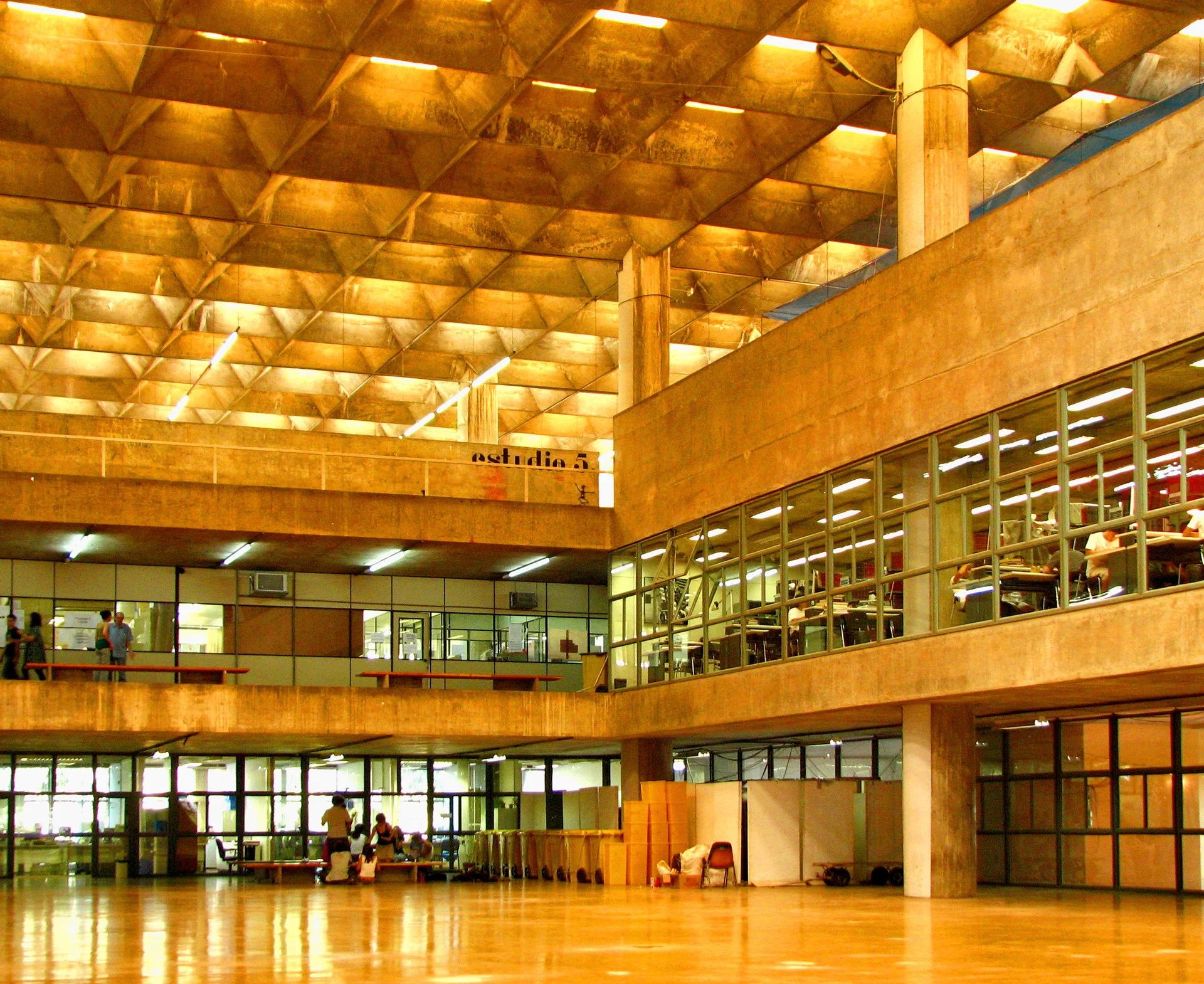 Ambiente de biblioteca com estantes de livros e mesas de estudo iluminadas