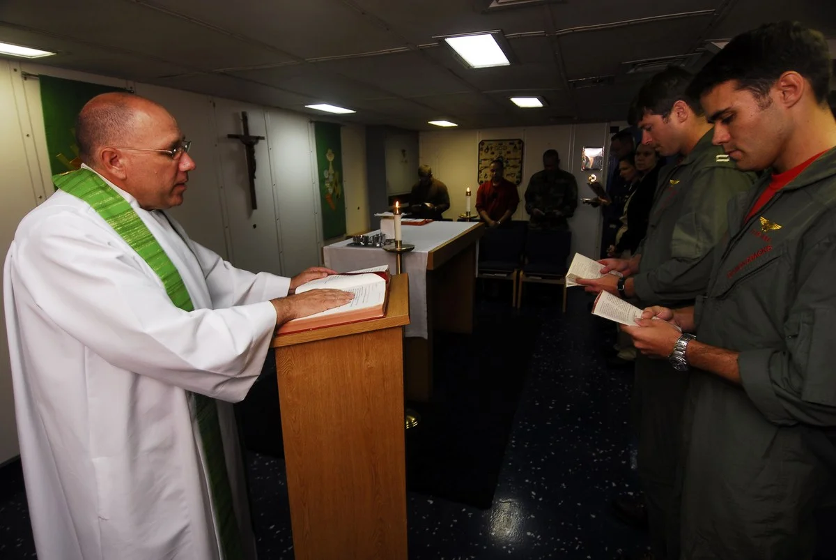 Capelão naval militar fardado conduzindo cerimônia e assistência religiosa em embarcação militar