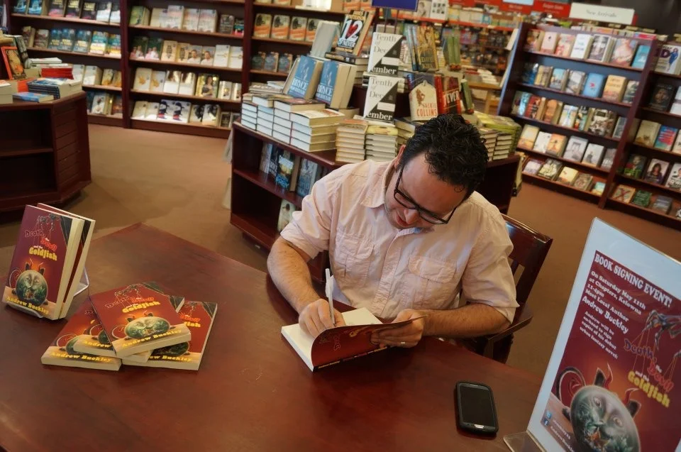 Escritor em sessão de autógrafos autografando seu livro para leitora, exemplificando como divulgar e vender livros
