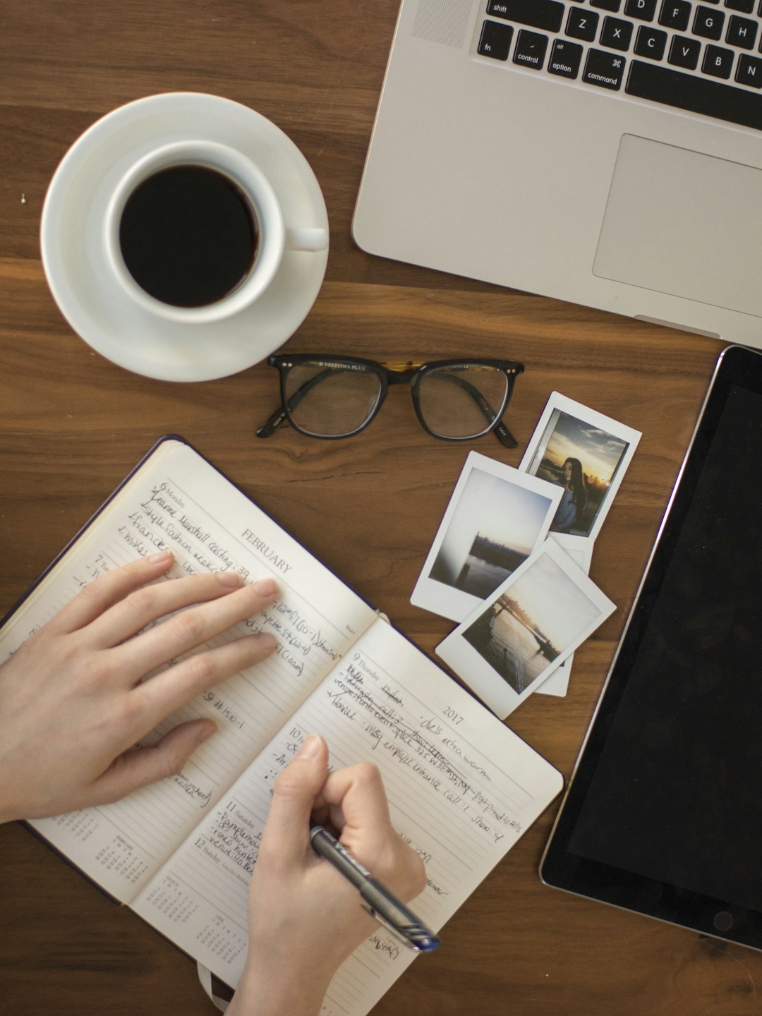Mesa de estudos minimalista com laptop, caderno de anotações e caneta sob luz suave