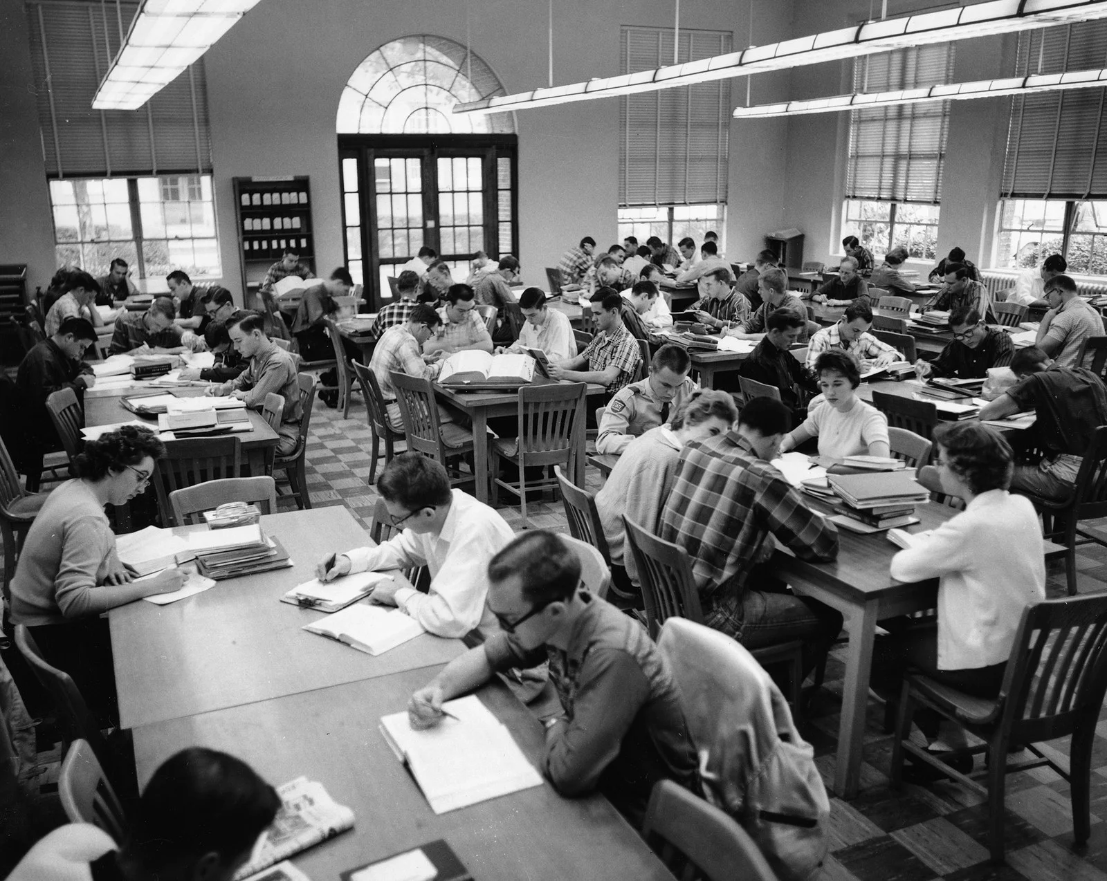 Estudantes em ambiente silencioso de estudo e biblioteca com anotações e livros abertos