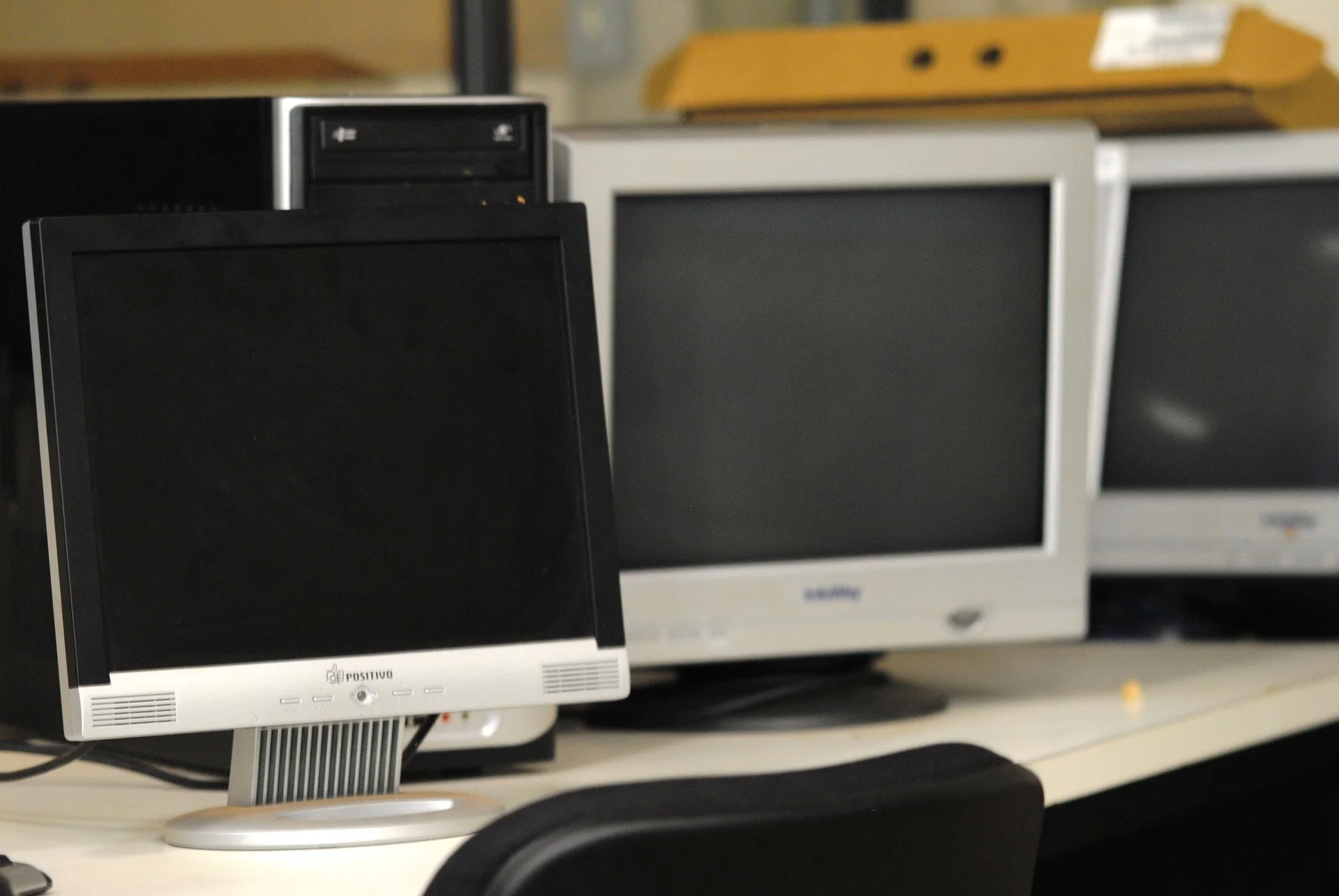 Monitores de computador em ambiente acadêmico iluminado