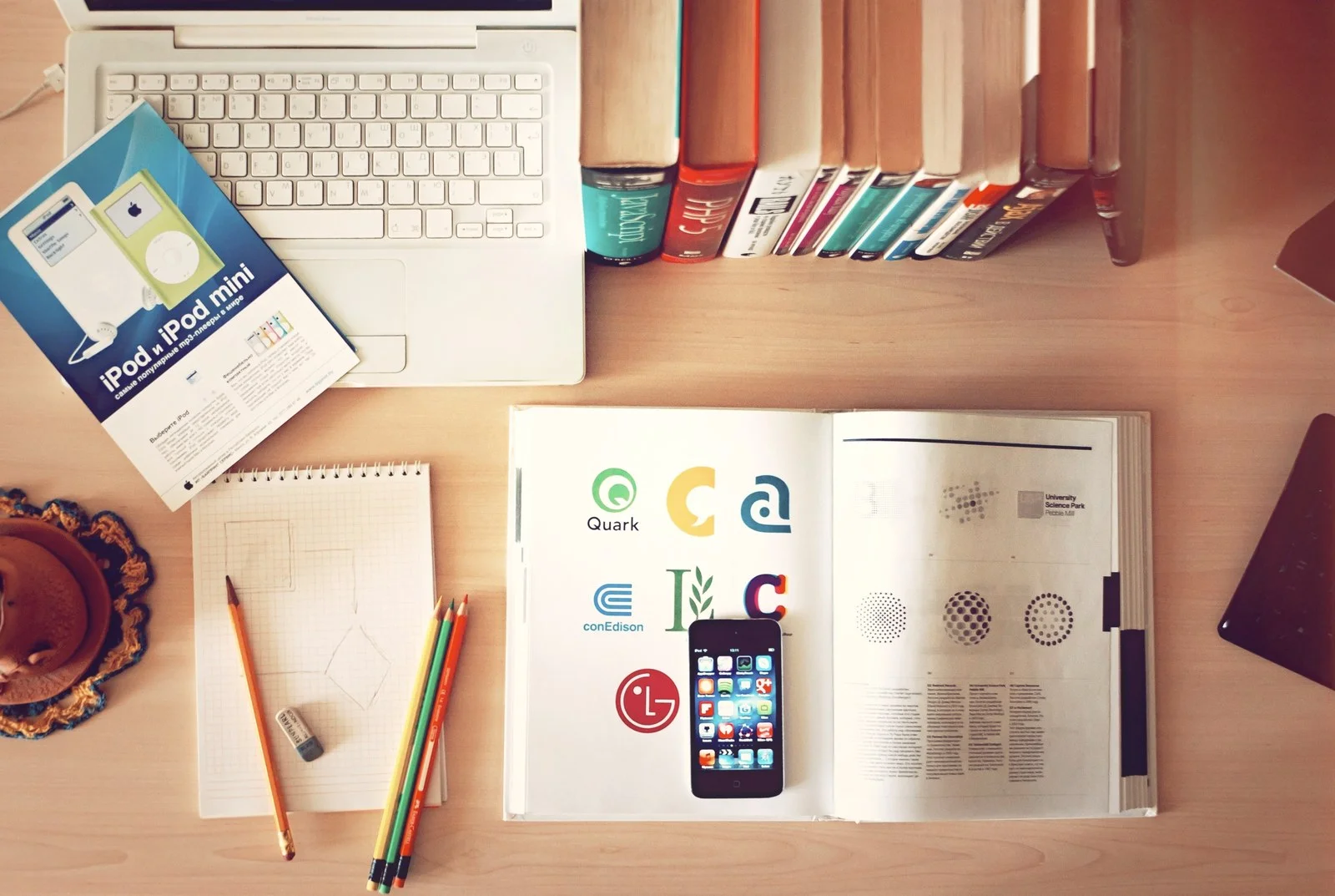 Mesa organizada com livros, laptop, caderno e lapis para planejamento de ciclo de estudos