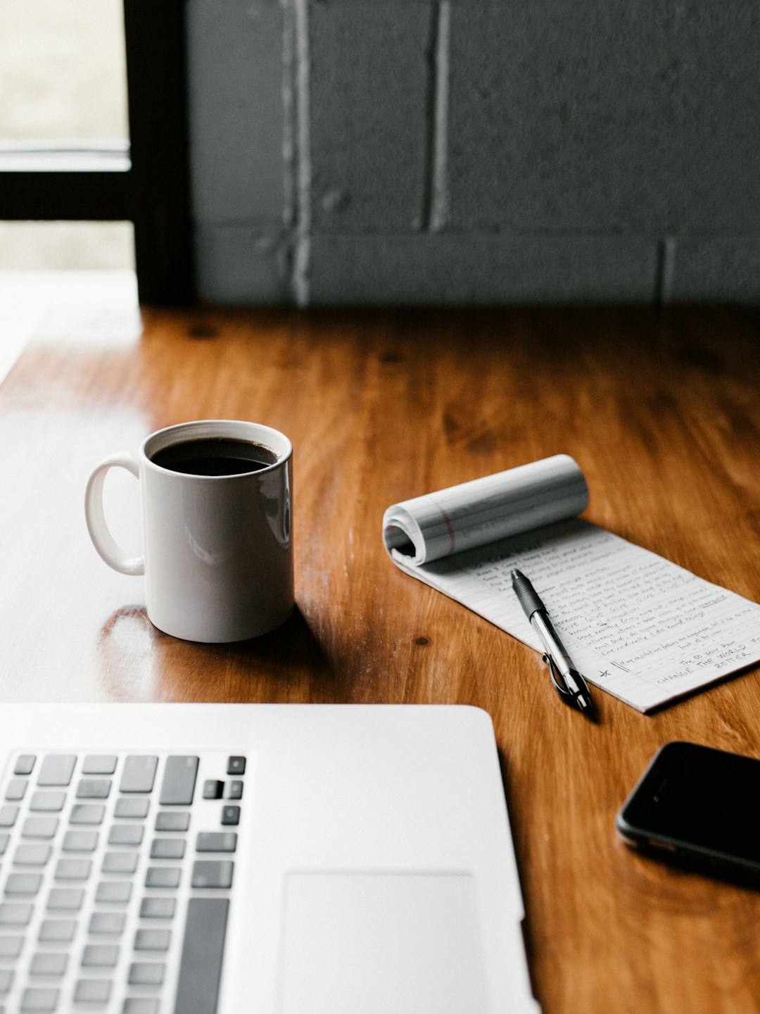 Pessoa revisando metas e cronograma de aprendizado pela manhã com café e laptop