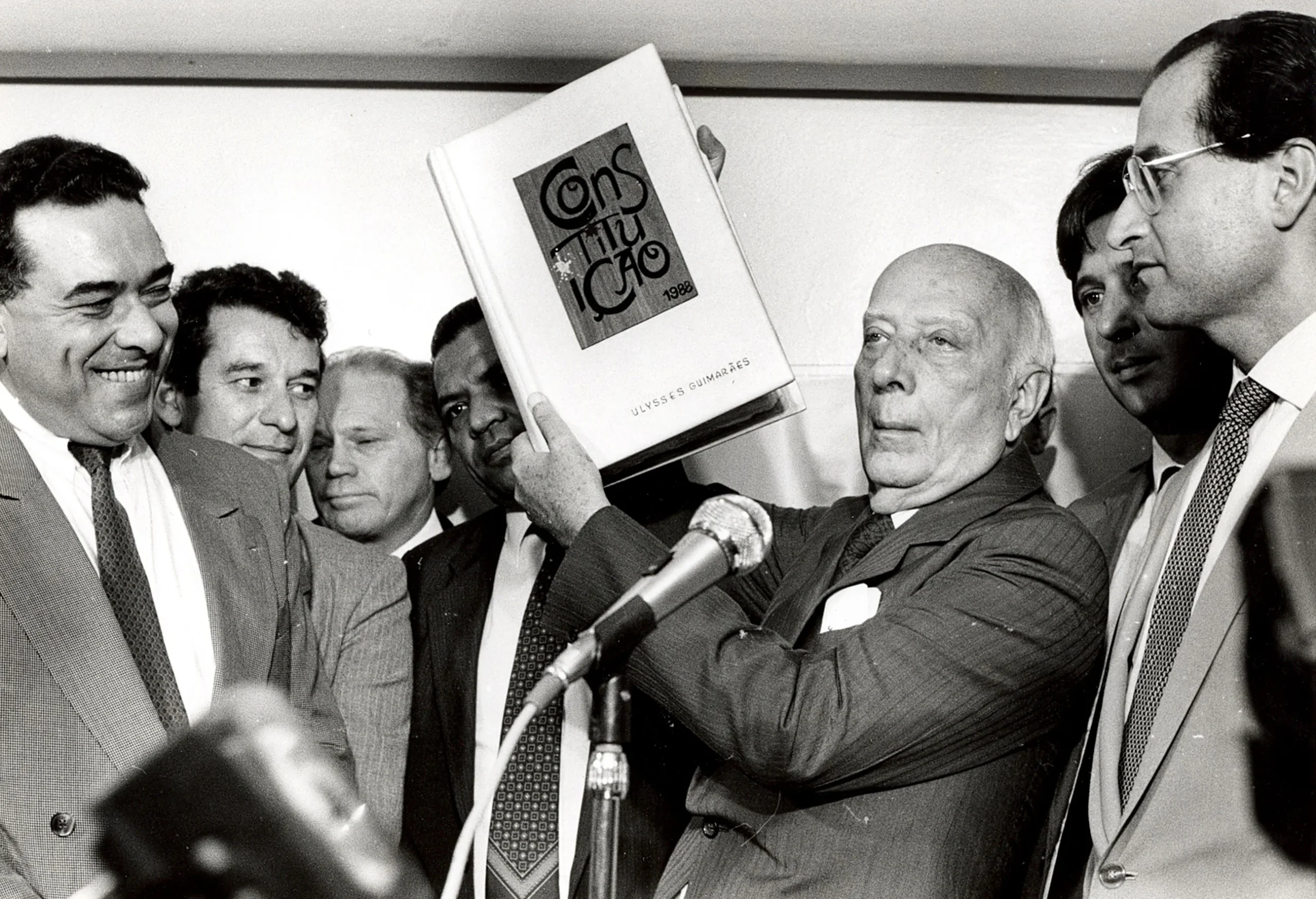 Ulysses Guimarães erguendo a Constituição Cidadã de 1988 que estruturou o Artigo 144 da Segurança Pública