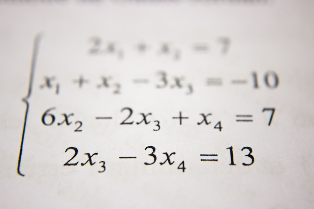 Prancheta com anotações matemáticas e instrumentos de medição e desenho técnico
