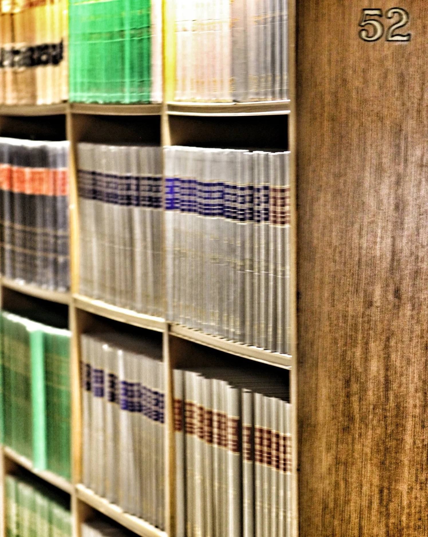 Volumes encadernados de obras jurídicas e legislação em estante de biblioteca no processo de estudar com NotebookLM
