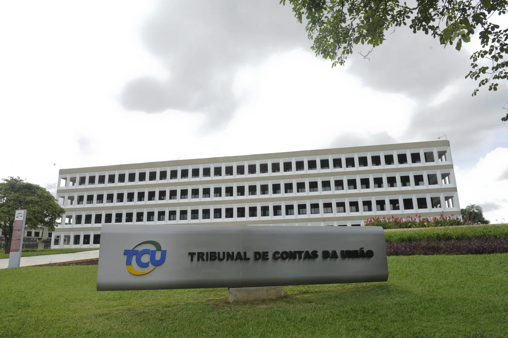 Fachada frontal do Tribunal de Contas da União em Brasília com arquitetura moderna e jardins amplos